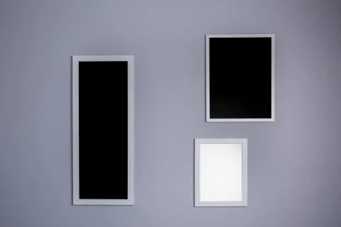 Poster mockup with three frames on empty grey wall Foto stock
