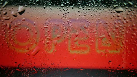A poster with the text "OPEN" covered by raindrops Stock Footage 80809461