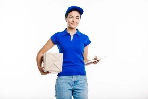 Postman poses at the camera with a parcel and a tablet. Stock Photos
