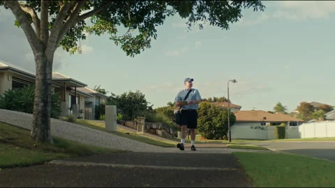 Postman with the postal bag walking towards his destination Stock Footage 263975971