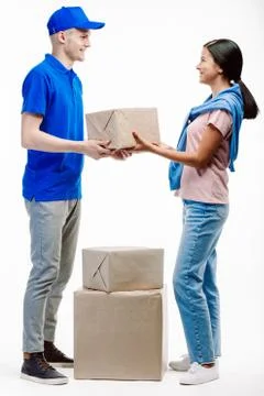 Postman takes parcels from the client at the post office. Stock Photos