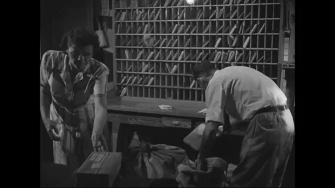 Postmaster Ed Hill removes and checks parcels in the post office - 1949 Stock Footage 109007343