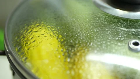 A pot with boiled corn under a closed transparent lid and boiling water Stock Footage 201291819