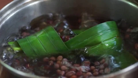 A pot of boiling pandan leaf and azuki beans porridge Stock Footage 75957559