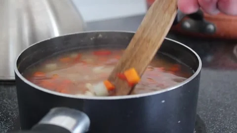 Pot of Boiling Soup Being Stirred on Stove Stock Footage 264702974
