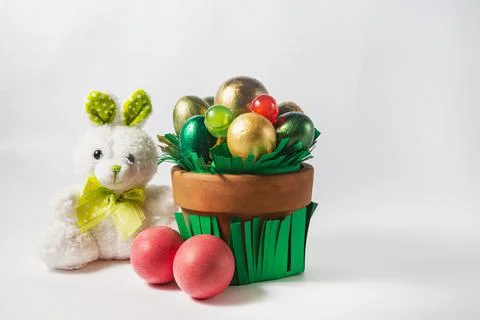 A pot of colored eggs, candy and a toy hare. Easter holiday concept Stock Photos