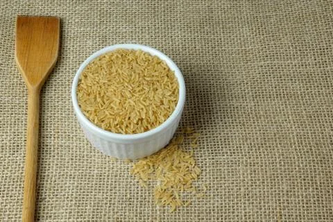 POT CONTAINING RAW INTEGRAL RICE ON A RUSTIC TABLE Stock Photos