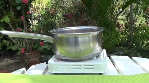 Pot cooking on a stove outside Stock Footage 138643733