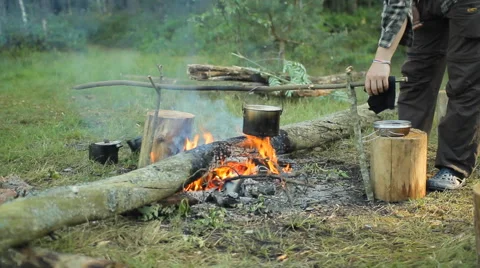 In a pot on the fire boiling water. A man removes scum and throws away Stock Footage 64444102