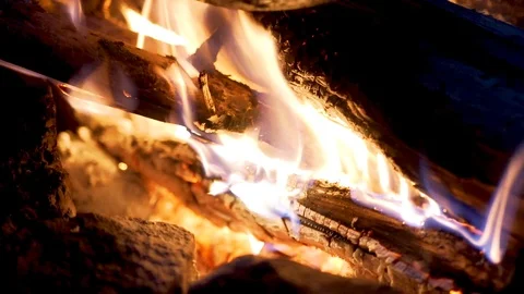 A pot hangs on a trinog on a fire, flames twine around it Stock Footage 102055559