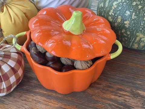 Pot of nuts, chestnuts and pumpkins on wooden old table. Composition for Stock Photos