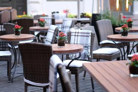 Pot with a red flower on the table of an empty street cafe Stock Photos