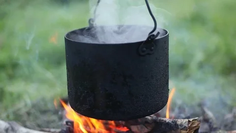 The pot of water hangs over the fire. Close-up. Stock Footage 83361009