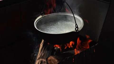 The pot of water hangs over the fire over mangal. The water boils. Close-up Stock Footage 167858646