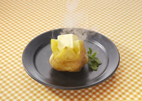 Potates topped with butter Stock Photos