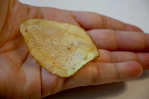 Potato Chip in Hand Close-Up, Snack Food and Eating Concept Stockfoto's