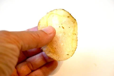 Potato Chip in Hand Close-Up, Snack Food and Eating Concept Fotos Stock