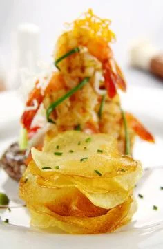 Potato Chip Stack Stack of crisp potato chips with a shrimp stack in the b... Stock Photos