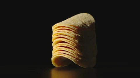 Potato chips are being stacked on a black surface. Stop Motion animation Stock Footage 135110455