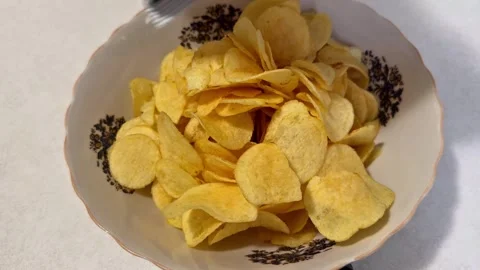 Potato Chips Being Poured from a Bag into a Bowl Stock Footage 344577506