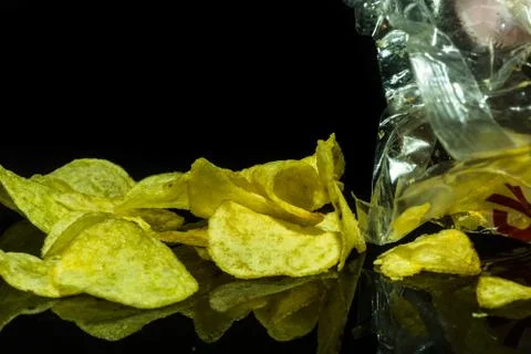 Potato chips on a black background Stock Photos