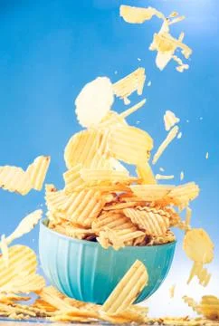 Potato chips, crisps flying inside a bowl. Foto stock