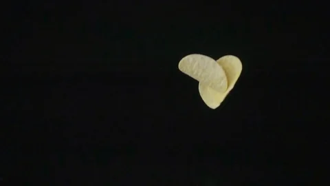 Potato chips on a dark background slowly fall down. Stock Footage 114684703