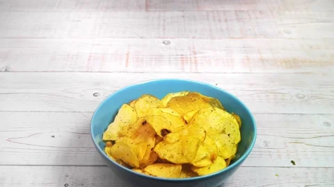 Potato chips falling into the ceramic bowl Stock Footage 162383315