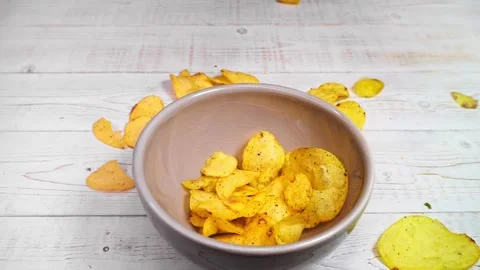 Potato chips falling into the ceramic bowl Stock Footage 193723297