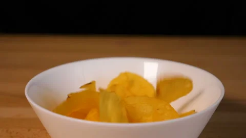 Potato chips falling into a plate Stock Footage 126707762