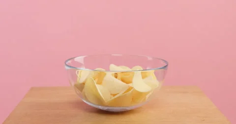 Potato chips falling into a plate Stock Footage 154087380
