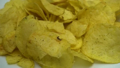 Potato chips falling on rotating plate close up. Stock Footage 86575321