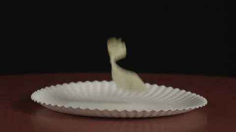 Potato chips falling in slow motion on paper plate 库存影片 32264643