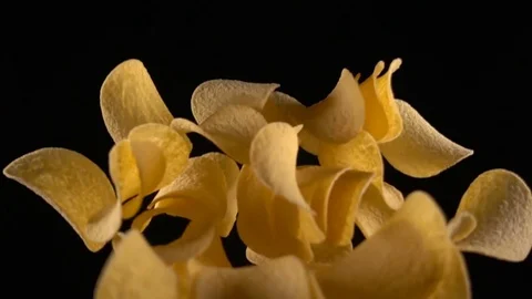Potato chips in free fall on a black background Stock Footage 84259212