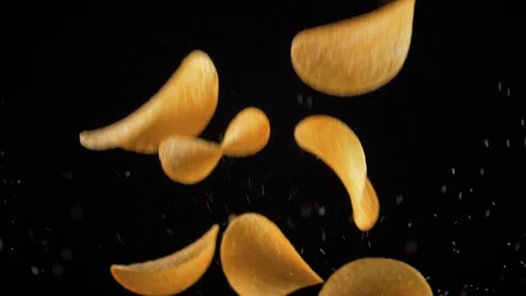 Potato chips in free fall on a black background. Pringles. Lays Stock Footage 94084665