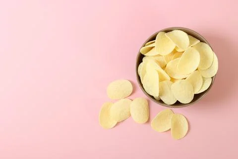 Potato chips in a plate on a colored background top view. Stock-Fotos