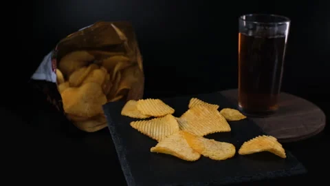Potato chips rotating on black slate Vidéo 344954992