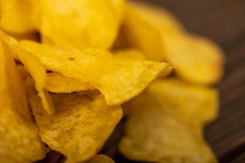 Potato chips scattered on the table, close-up, selective focus. Stock Photos
