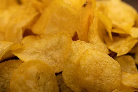 Potato chips scattered on the table, close-up, selective focus. Stock Photos