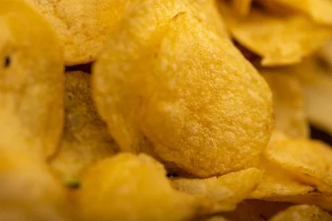 Potato chips scattered on the table, close-up, selective focus. Stock Photos
