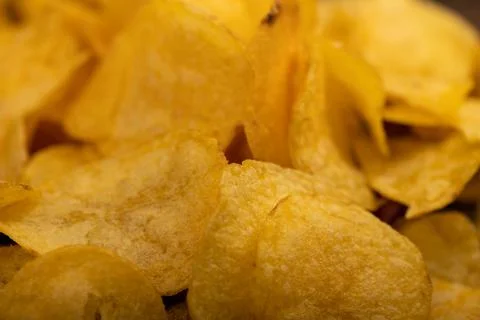 Potato chips scattered on the table, close-up, selective focus. Stock Photos