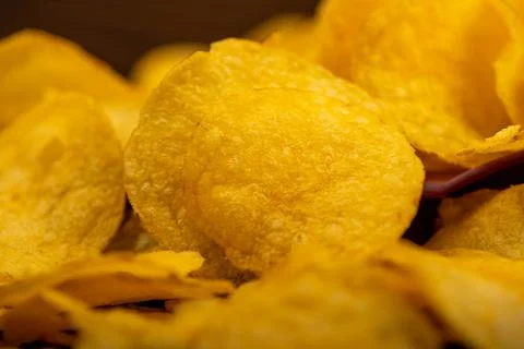 Potato chips scattered on the table, close-up, selective focus. Stock Photos