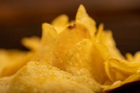 Potato chips scattered on the table, close-up, selective focus. Stock Photos