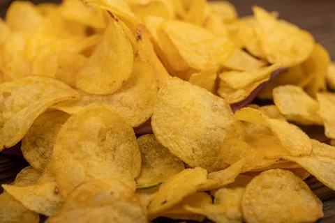 Potato chips scattered on the table, close-up, selective focus. Stock Photos