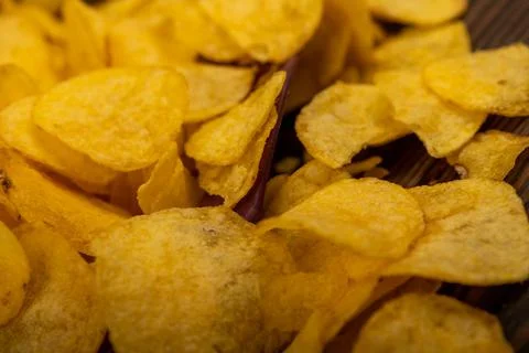 Potato chips scattered on the table, close-up, selective focus. Stock Photos