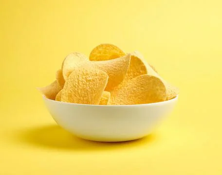 Potato chips on yellow background Stock Photos