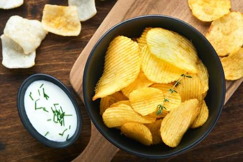Potato corrugatedchips. Fast food. Crispy potato chips ceramic black bowl wit Stock Photos
