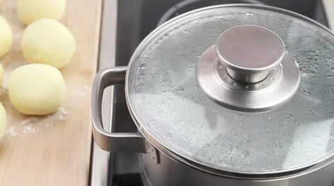 Potato dumplings being placed in salt water Stock Footage 24646794
