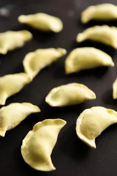 Potato dumplings on a black surface ready for cooking in a kitchen setting Stock Photos
