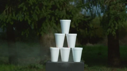 Potato gun shooting stack of cups with colorful liquids in super slow motion. Stock Footage 101035468